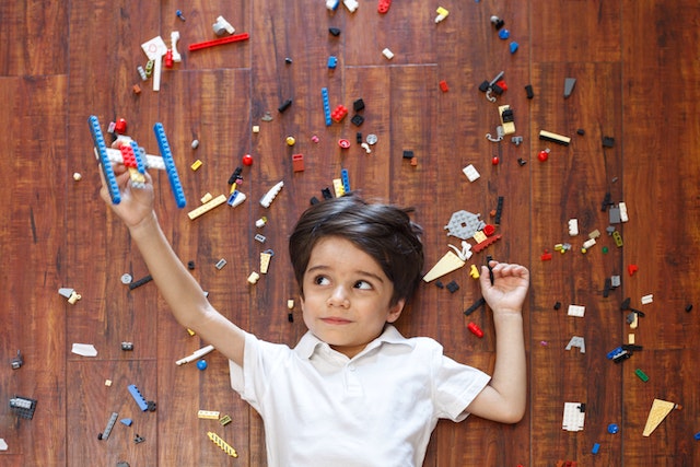 Junge mit Legos auf dem Boden