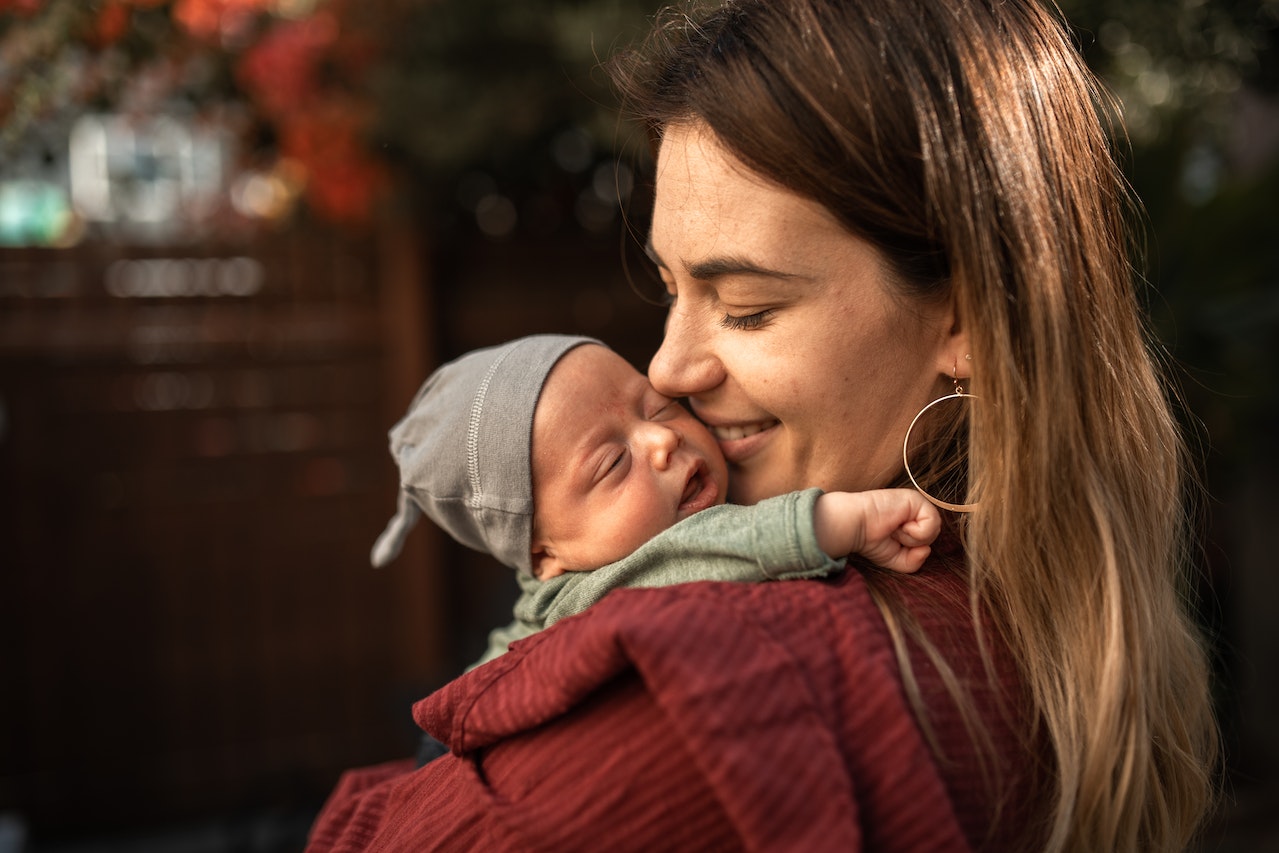 neue mama trägt neugeborenes baby